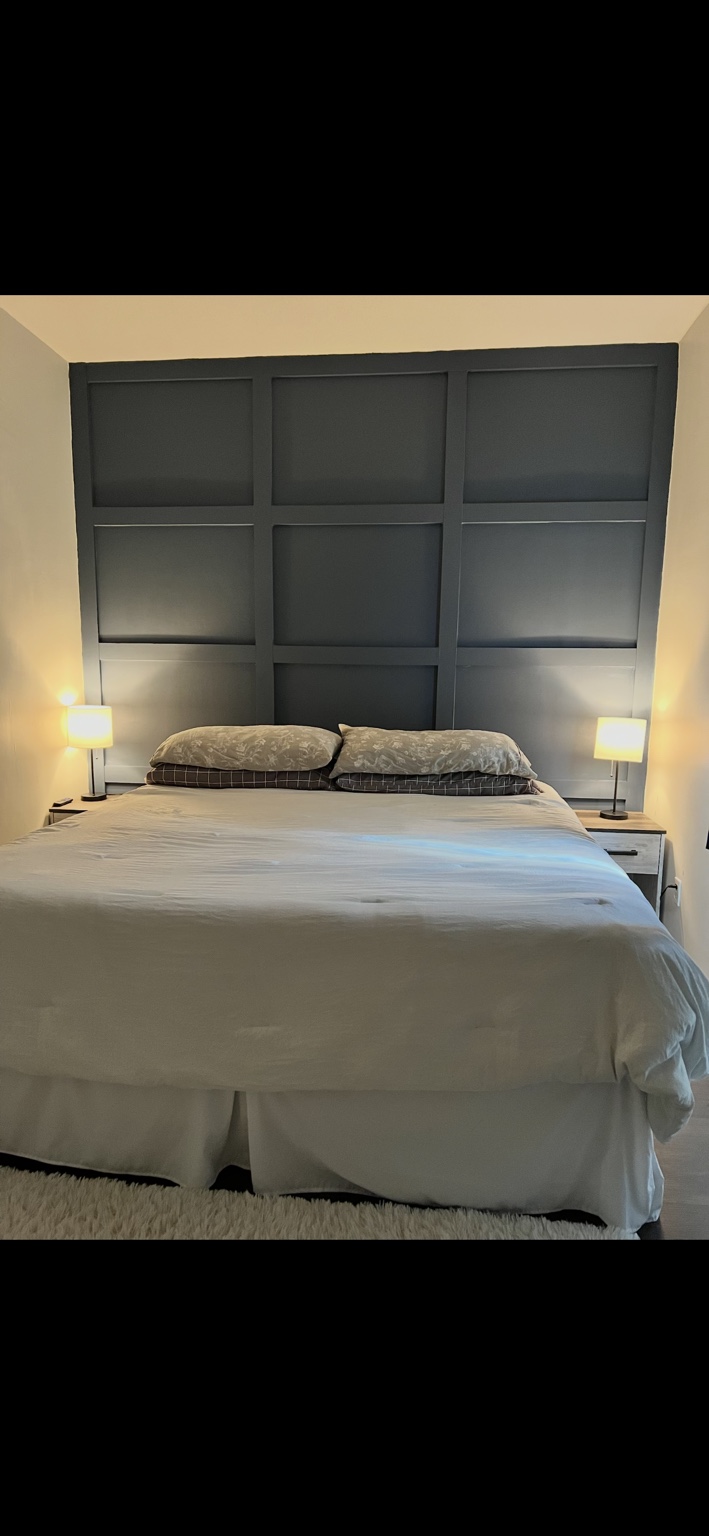 Dark grid accent wall behind a bed